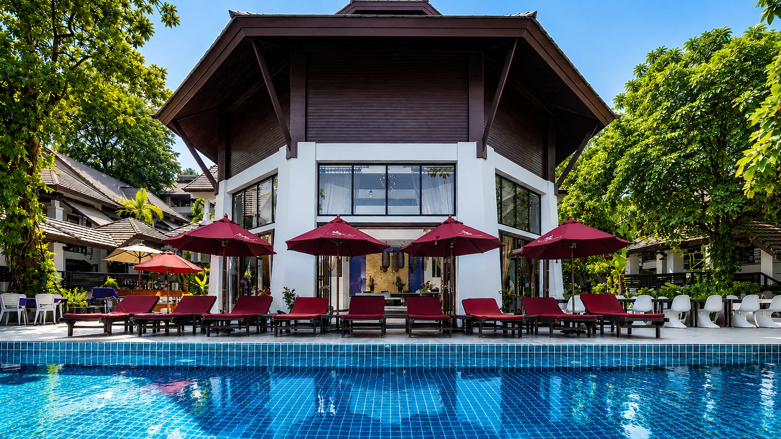 Daytime swimming pool with pink loungers at Samed Pavilion Resort